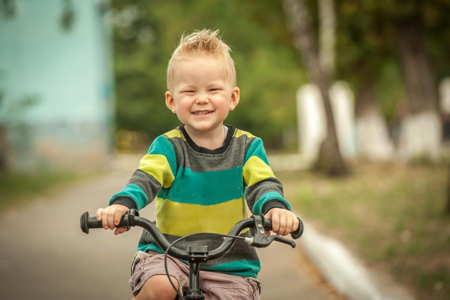 jongen rijdt met zijn fiets op straat