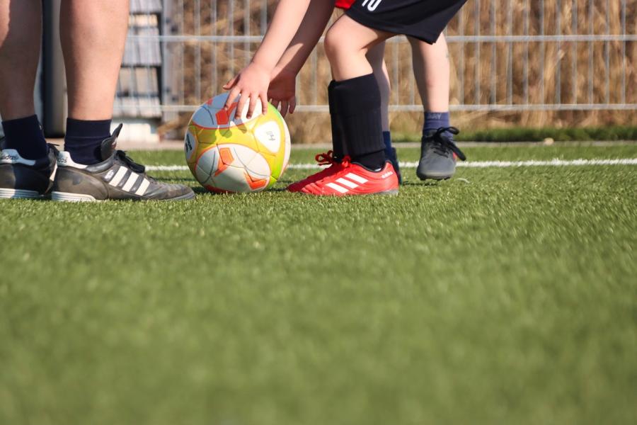 kunstgrasveld met voetbal en spelers